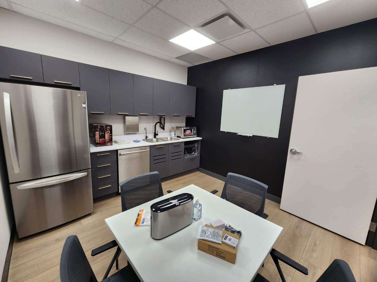 Commercial break room renovation with dark accent wall by Malamar Construction